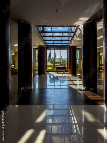 Hotel entrance or lobby with natural light and a piano.
