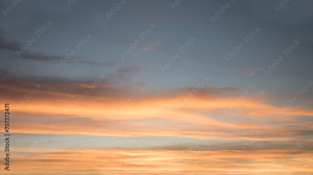 sunset scenery with yellow and orange lighted cloud bands and blue gray above