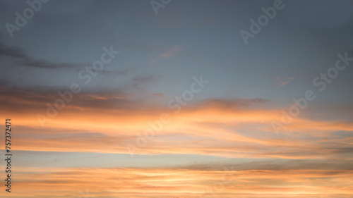 sunset scenery with yellow and orange lighted cloud bands and blue gray above