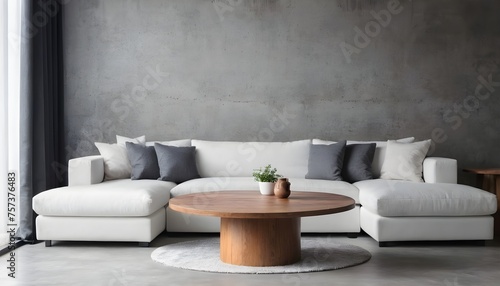 Round wood coffee table near grey corner sofa in room with concrete wall. Minimalist  loft home interior design of modern living room.