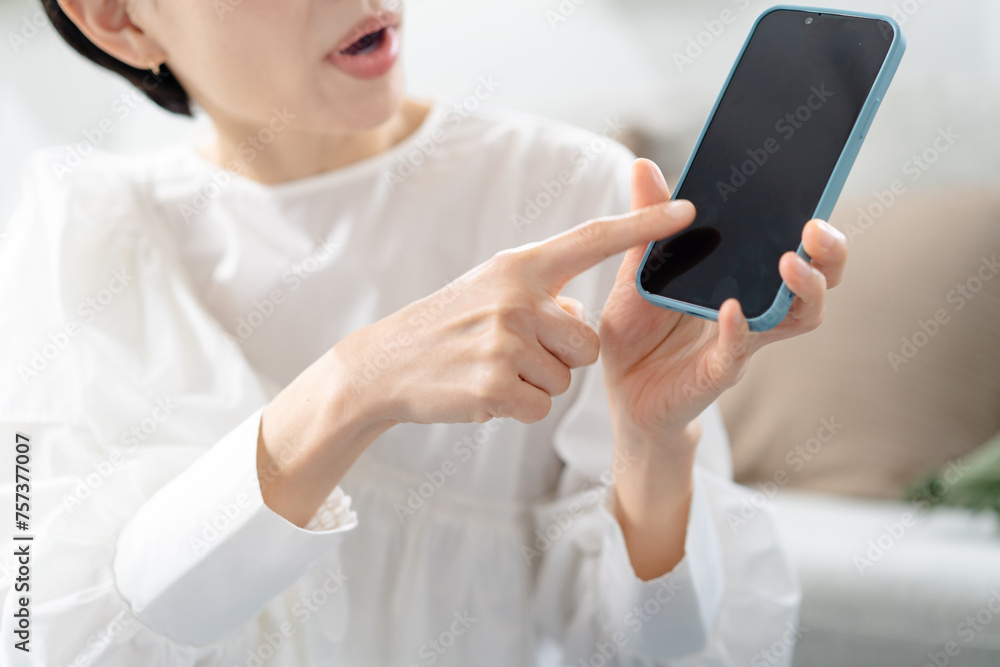 スマホを見て怒る女性 スマホを見て怒る女性