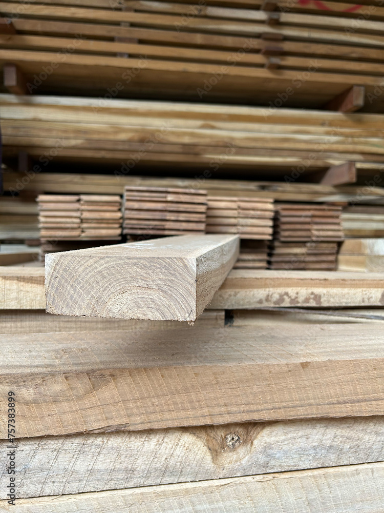 Lumber planks stack in the sawmill.  Stacked of woods on ground in furniture factory