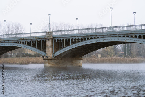Enrique Estevan Bridge, also known as New Bridge, over the Tormes River in Salamanca (Castilla y León). Metal bridge supported by granite pillars. Bridge photographed on a cold winter day.