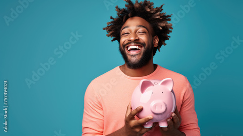 Man smiling broadly, and holding a piggybank, signifying responsible financial planning and savings.