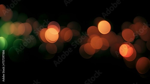Bright colorful abstract bokeh circles moving around. Green,orange and red design. Abstract colorful pattern with defocused lights on black background with space for your text. contains transparencies photo