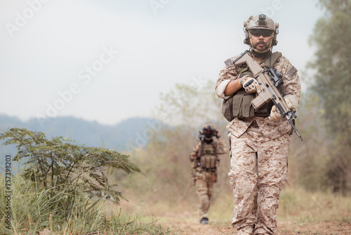 Soldiers in camouflage military uniforms carrying weapons, Reconnaissance missions in the tropical forest area, Assault infantry battle training. © Wosunan