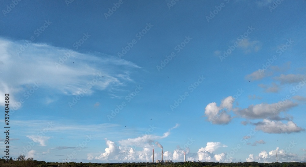 Industrial landscape with blue sky and white clouds. Panoramic view.