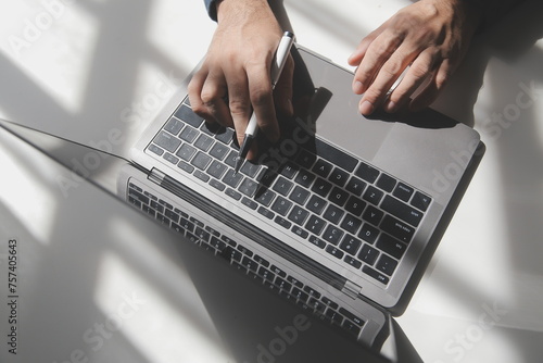 Cropped image of a young man working on his laptop in a coffee shop, rear view of business man hands busy using laptop at office desk, young male student typing on computer sitting at wooden table photo