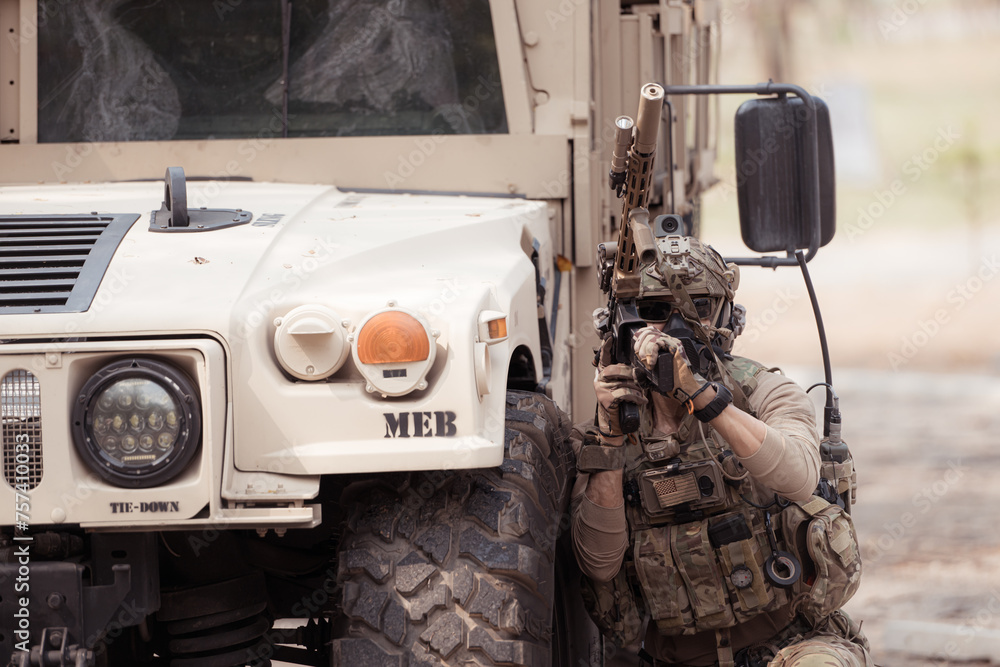 Soldiers in camouflage uniforms hold weapons ready to fire, By hiding on the side military communication vehicle