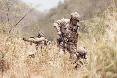 Soldiers in camouflage military uniforms carrying weapons  Reconnaissance missions in the tropical forest area with mission of helping those injured from being shot