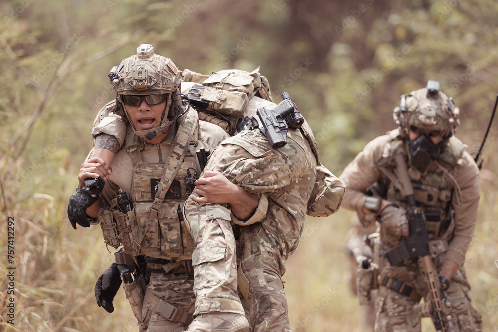 Soldiers in camouflage military uniforms carrying weapons, Reconnaissance missions in the tropical forest area with mission of helping those injured from being shot