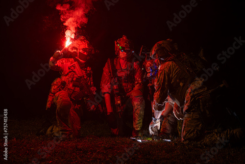 Group of soldiers in camouflage uniforms hold weapons with patrol missions at night