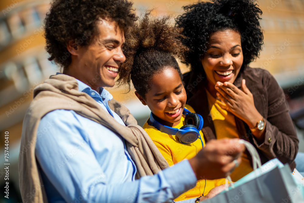 Happy young mixed race couple spending time with their daughter in shopping. Happy young mixed race couple spending time with their daughter in shopping.