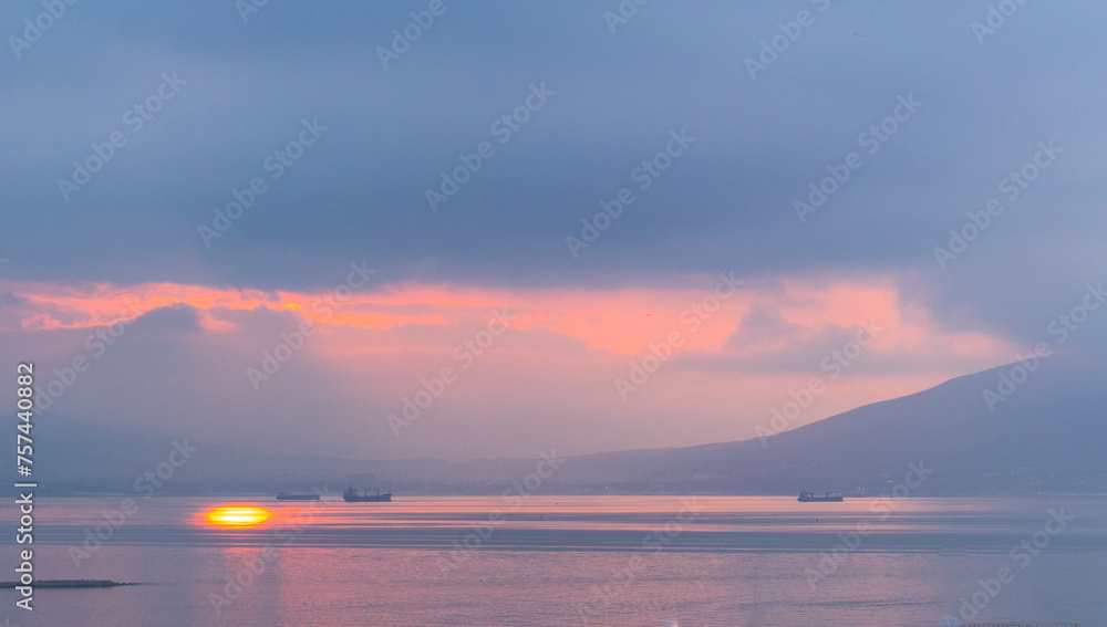 dawn over the sea with ships and sun