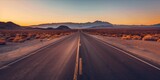 Open road in a vast desert landscape at sunset