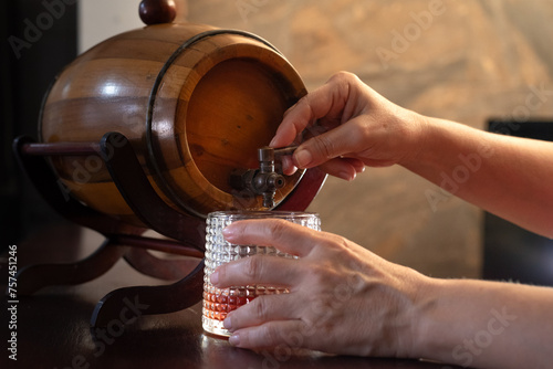 Hands pouring a drink from a barrel photo