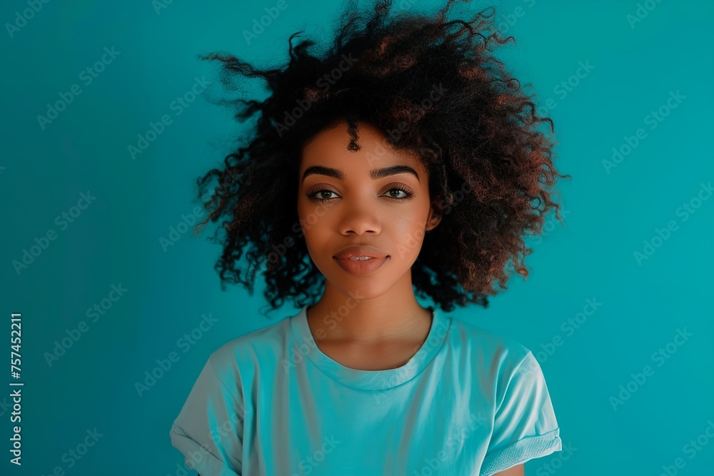 A woman with curly hair is wearing a blue shirt and smiling A woman with curly hair is wearing a blue shirt and smiling