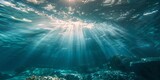 Underwater view with sunlight piercing through the ocean's surface.
