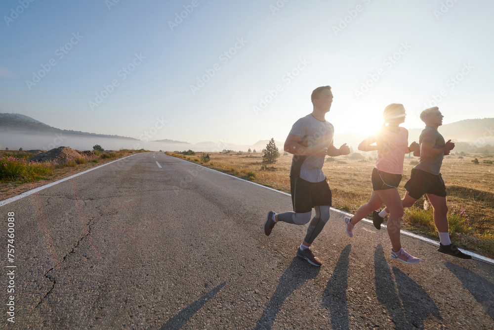 A group of friends, athletes, and joggers embrace the early morning hours as they run through the misty dawn, energized by the rising sun and surrounded by the tranquil beauty of nature A group of friends, athletes, and joggers embrace the early morning hours as they run through the misty dawn, energized by the rising sun and surrounded by the tranquil beauty of nature