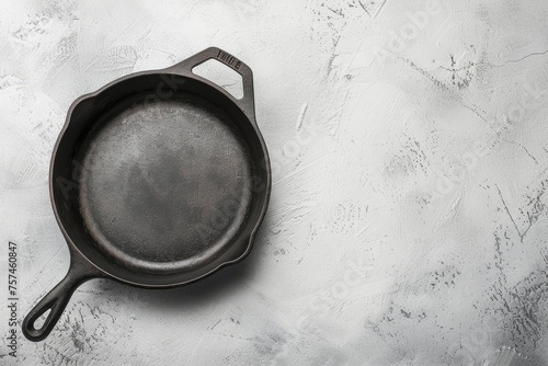 A cast iron skillet is placed on a table, ready for cooking or food preparation. The background offers ample space for text or food