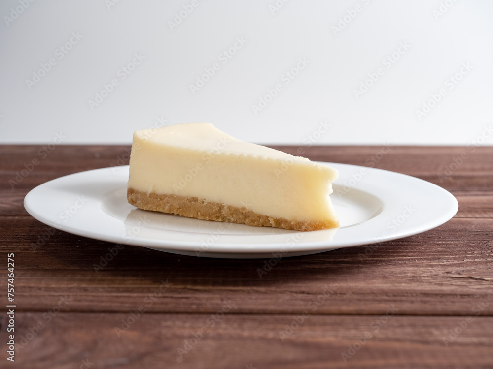 delicious cheesecake on a white plate. Wooden background, front view