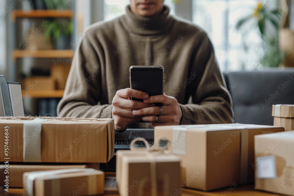 A person in a cozy sweater manages their online business, using a smartphone with shipping packages ready for dispatch on the table. A person in a cozy sweater manages their online business, using a smartphone with shipping packages ready for dispatch on the table.