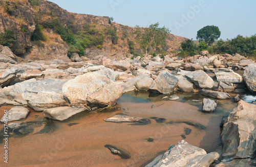 flow of Telwa river stream falling through levels of rocky terrain at Dharhara falls in Simultala, Bihar. Water level is knee-deep as flow of water is mostly dried-up in winter season. photo