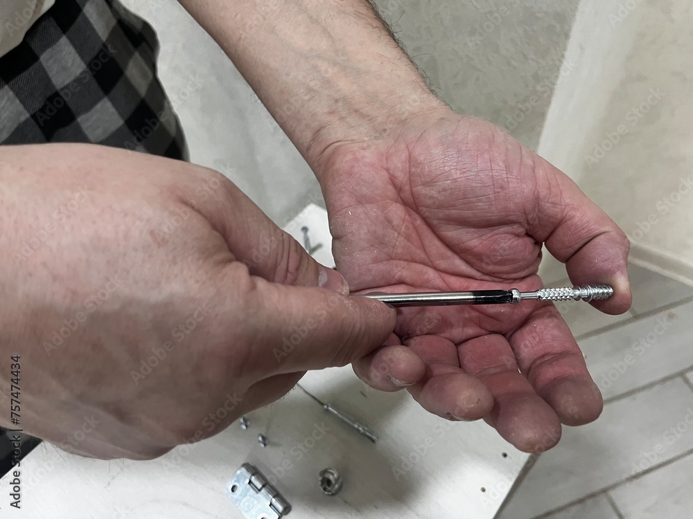 Close-up of a screwdriver in the hands of a man. Close-up of a screwdriver in the hands of a man.