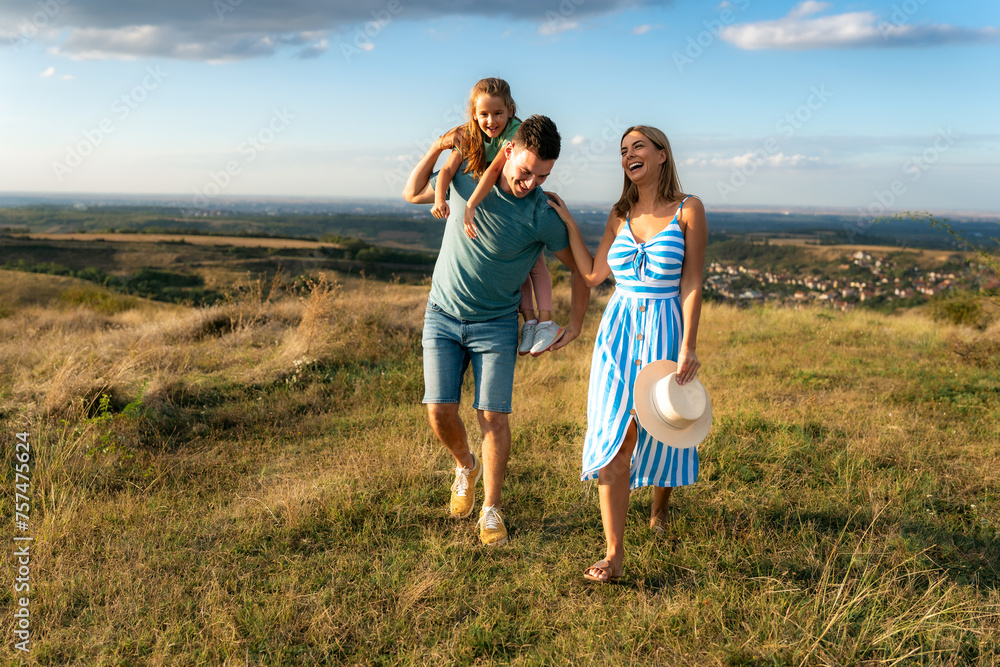The father jokes with his daughter while he walks with his wife in the field, the stepmother spends time with her stepdaughter and her husband The father jokes with his daughter while he walks with his wife in the field, the stepmother spends time with her stepdaughter and her husband