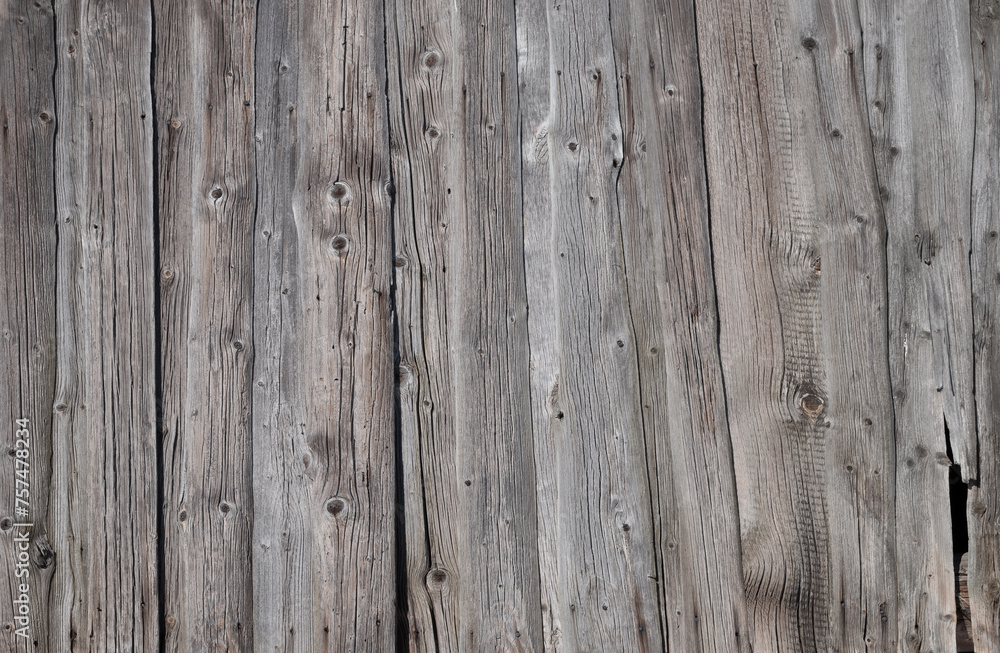 Texture of old weathered unpainted wooden plank fence