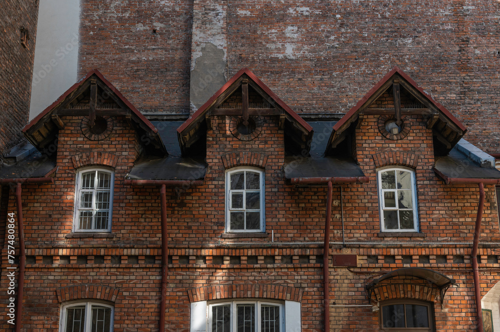 Fototapeta premium Stara zabytkowa kamienica w centrum warszawy na ulicy Hożej o nietypowym kształcie z czerwonej cegły.
