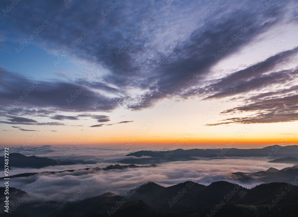 Sunrise. Foggy morning. Scenery with high mountains. Orange sky. Forest. Wild Carpatian touristic place. Natural landscape.