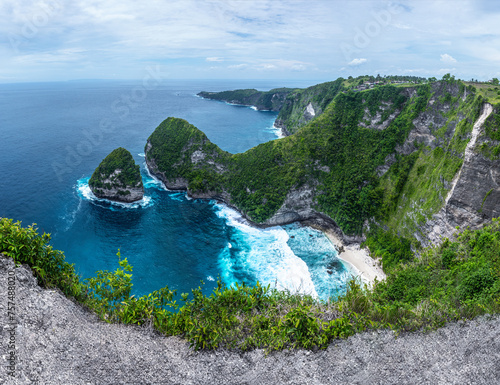 Landscape of sunny day with turquoise ocean, blue sky and mountains. Kelingking Beach is an incredible little cove on Nusa Penida Bali island, Indonesia. Mountain scenery. Wallpaper background.