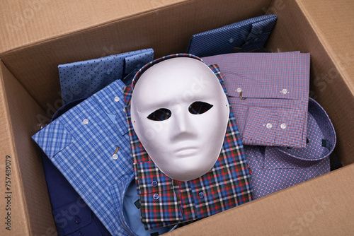 White mask and various shirts in an open cardboard box, concept on the theme of smuggling
