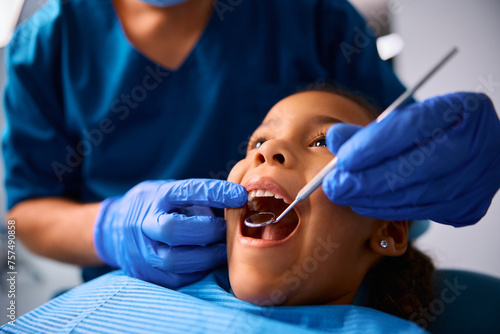 Black little girl during teeth examination at dentist's office.