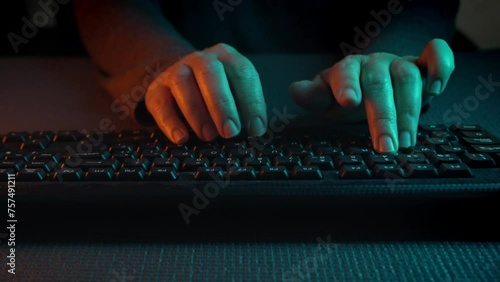 Primer plano de las manos escribiendo en el teclado. Luces de neón verdes y naranjas iluminan los laterales. Ciberpunk. 60 fps.