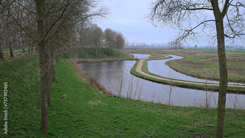 Winter polder view on a canal with a bicycle path created in the middle in Sluis, Zeelandic Flanders, The Netherlands photo