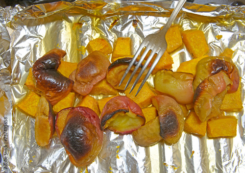 Pieces of pumpkin and apple baked on metal paper. photo