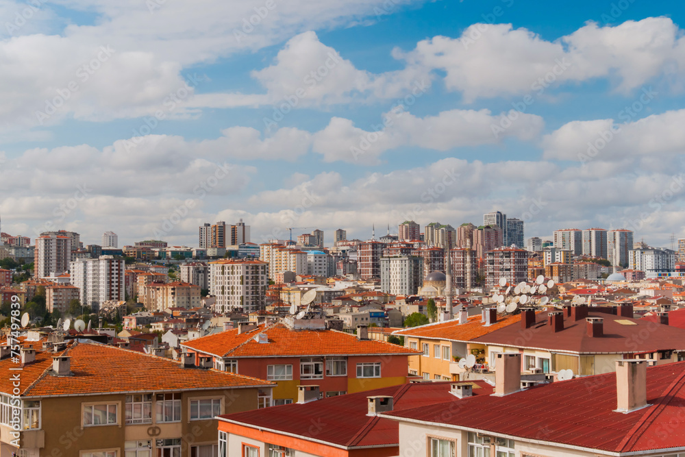 View of white clouds in the blue sky over the roofs of typical turkish apartment, residential buildings in Istanbul - afternoon, daylight. Cityscape, urban and architecture concept