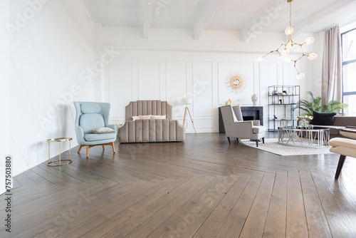 Modern luxury stylish apartment interior in pastel colors. a very bright room with huge windows filled with daylight. white walls  wooden parquet floors and a dark marble fireplace