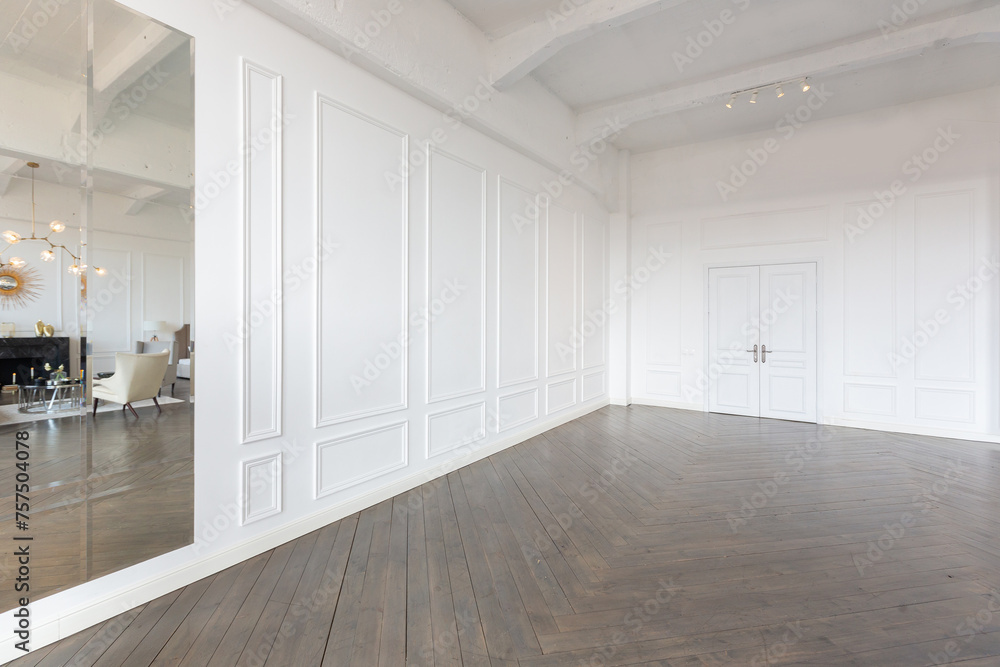Obraz premium Modern luxury stylish apartment interior in pastel colors. a very bright room with huge windows filled with daylight. white walls, wooden parquet floors and a dark marble fireplace