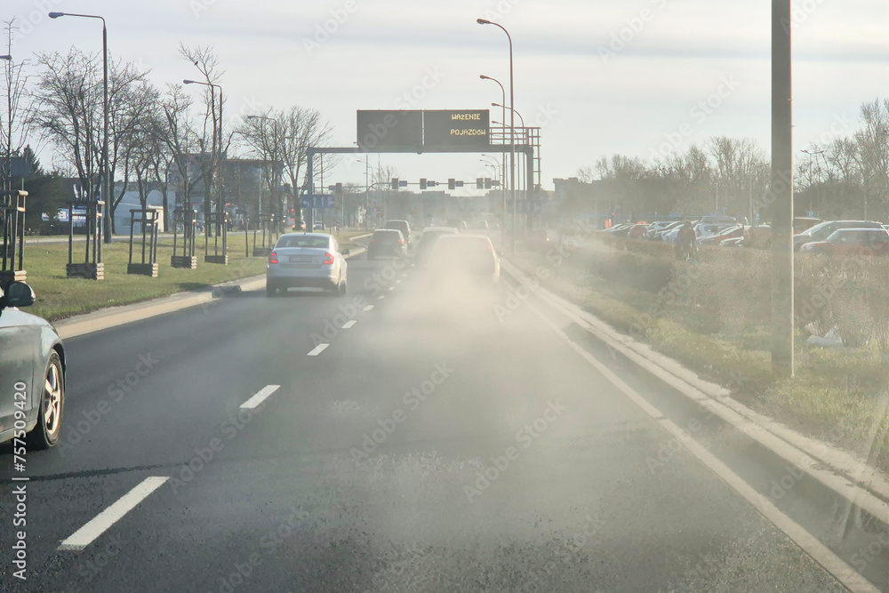 Niebezpieczny dym wylatuje z tłumika samochodu jadącego w korku w mieście. Zadyma - obrazy, fototapety, plakaty 