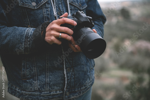 Close-up professional camera in the hands of male traveler photographer