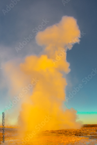 Stokkur geyser spectacular eruption in front of the sun , Iceland