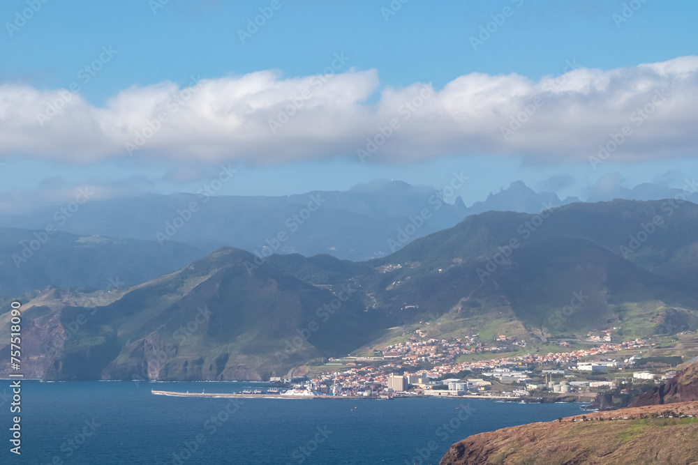 Panoramic view of coastal village Canical at majestic Atlantic Ocean coastline seen from Ponta de Sao Lourenco peninsula, Madeira island, Portugal, Europe. Hiking trail along steep rocky rugged cliffs