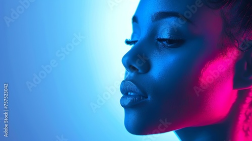 Portrait of a beautiful young woman with dark skin and blue eyes. She is wearing a blue dress and has her hair pulled back.