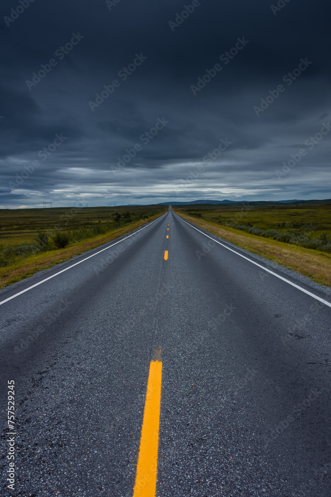 Epic cloudy landscape of an empty highway through the tundra of  Norway