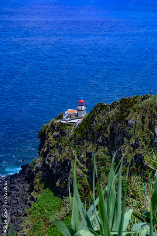 Lighthouse next to the sea from the mountain