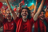 Jubilant Supporters in Red Celebrate a Spectacular Goal at Evening Soccer Match