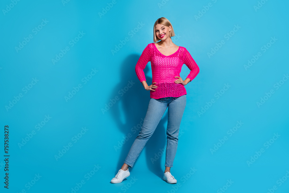 Full length photo of lovely young lady posing model defile shopping dressed stylish pink knitwear garment isolated on blue color background Full length photo of lovely young lady posing model defile shopping dressed stylish pink knitwear garment isolated on blue color background